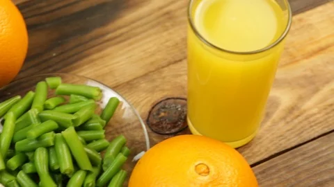 Healthy food, green string beans, bread rolls and orange on a table Stock Footage 123177632