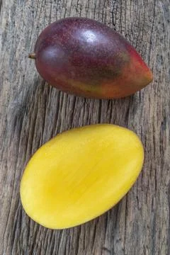 Healthy food red mango fruit has leaf on rustic wood table background. Stock Photos