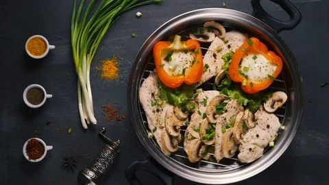 Healthy food steamed chicken dish with mushrooms and vegetables on a black Stock Footage