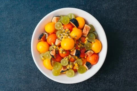 Healthy fruit platter. Selective focus. Bowl of cut colorful mango, figs, gra Stock Photos