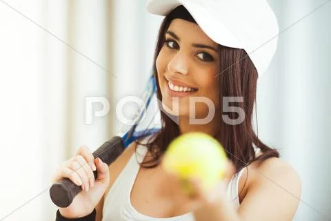 Healthy happy woman poses with a tennis racket while holding tennis ball Stock Photos