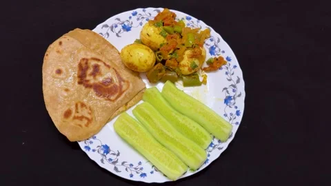 Healthy Indian Breakfast Plate With Egg Masala Roti and Cucumber slice Stock Footage 339476323