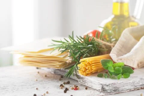 Healthy ingredients on a kitchen table - spaghetti, olive oil, tomatoes, sp.. Stock Photos