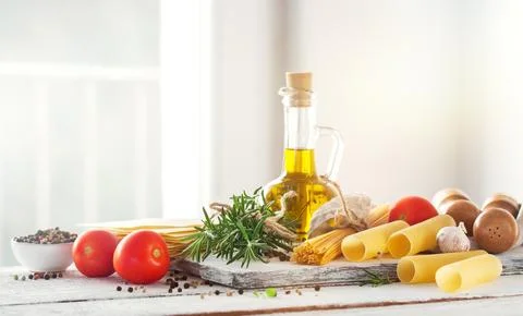Healthy ingredients on a kitchen table - spaghetti, olive oil, tomatoes, sp.. Stock Photos