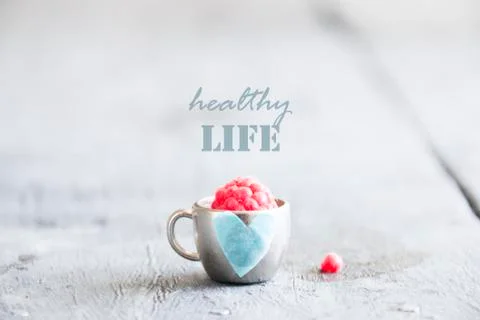 Healthy life idea - text, raspberry and cup with a heart Stock Photos