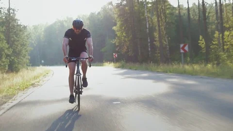Healthy man doing exercise riding a bicycle outdoors early in the morning Vídeo Stock 74548343