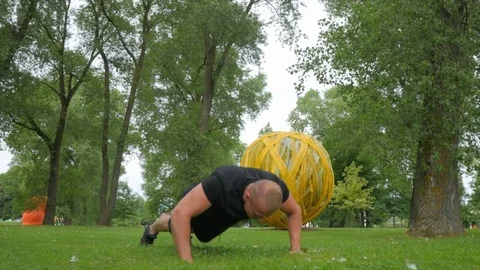 Healthy man doing squats outside in park close up slow motion shot Video stock 84003371