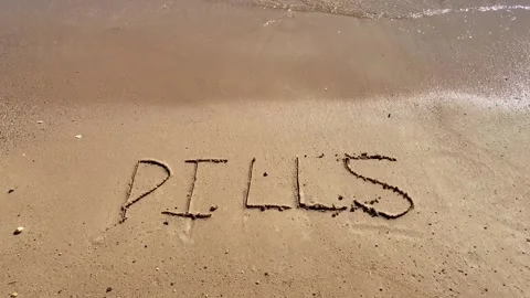 Healthy New Year concept. Text Pills handwritten in sand surface and blue s.. Video stock 251801577