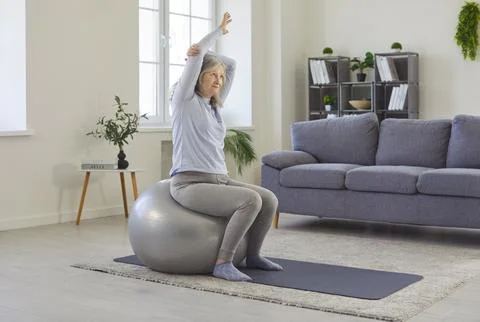 Healthy physical exercise, active workout of senior woman sitting on fitness Stock Photos
