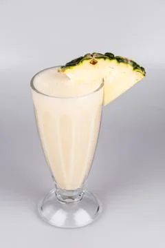 Healthy pineapple shake with a slice of pineapple on isolated white background Stock Photos