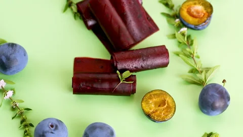 Healthy plum snack with fruit leather rolls on green background Stock Footage 345336546