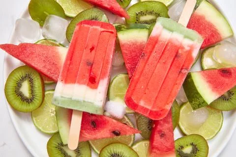 Healthy refreshing homemade ice cream lolly in a plate with melting ice cubes Stock Photos