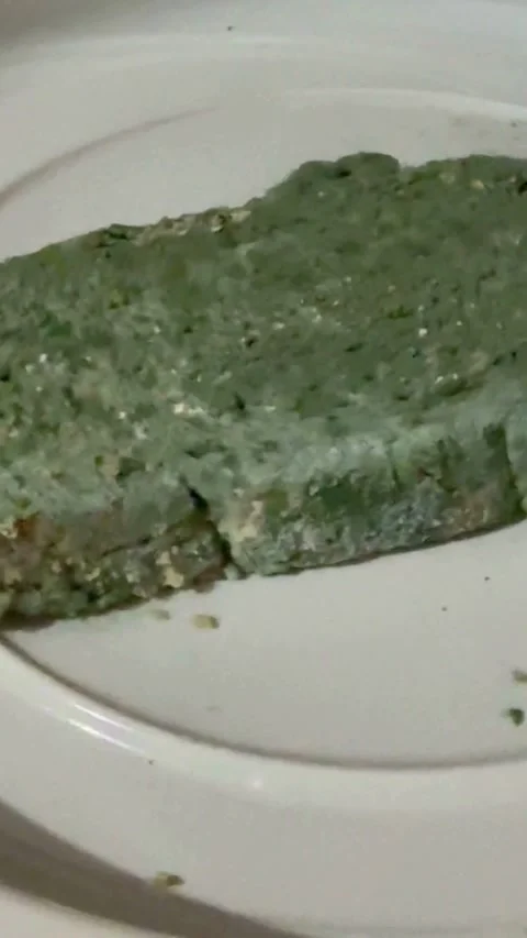 Healthy slice of green herb bread on white plate Video stock 331983115