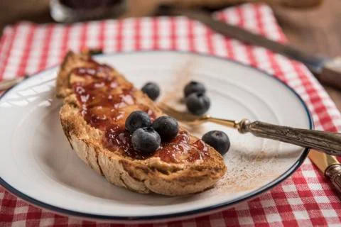 Healthy snack with toasted rustic bread with peanut butter and strawberry jam Stock Photos