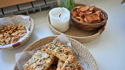 Healthy snacks on the table with apple chips nuts and cookies 4K Stock Footage 168986426