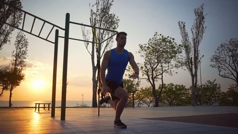 Healthy strong man engaged in trx exercises jump workout outdoor dawn slowmotion Stock Footage 76776901