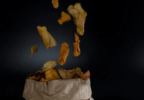 Healthy vegetable chips falling in a paper bag Stock Photos