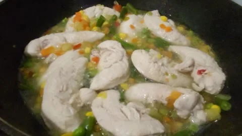 A healthy vegetable dish with pieces of chicken fillet is being prepared in a fr Stock Footage 273698328