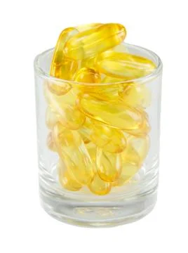 Healthy vitamin glass : yellow oil pills in translucent glass Stock Photos