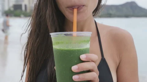 Healthy woman drinking green vegetable smoothie  for wellness and health Stock Footage