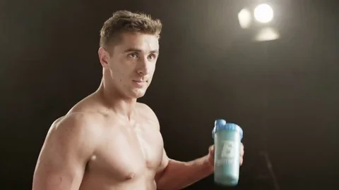 Healthy young man shaking a bottle Stock Footage 69236896