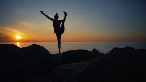 Healthy young woman practicing yoga on the cliff in the nature dawn slow motion Stock Footage