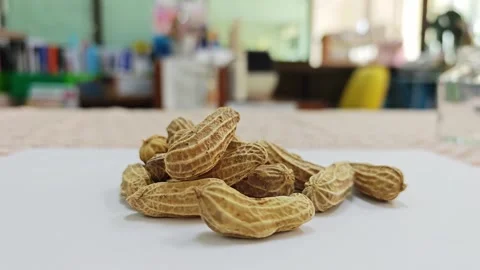 Heap of boiled peanuts in shells on white surface with blurred background. Stock Footage 339991023