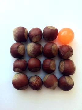 Heap of chestnuts isolated on white background with orange ball. Stock Photos