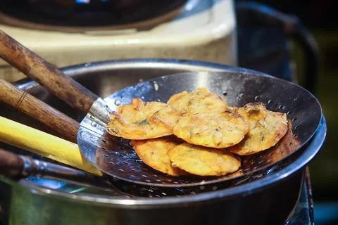 Heap of Crispy Fried Bakwan Vegetable Fritters Resting on Metal Skimmer Ove.. Stock Photos