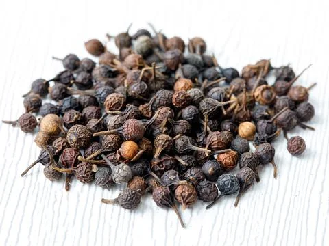 Heap of cubeb tailed pepper macro. Piper cubeba top view on white background Stock Photos