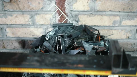 Heap of cut metal scrap in the workshop, steel pieces mixed with swarf after the Stock Footage 262562608
