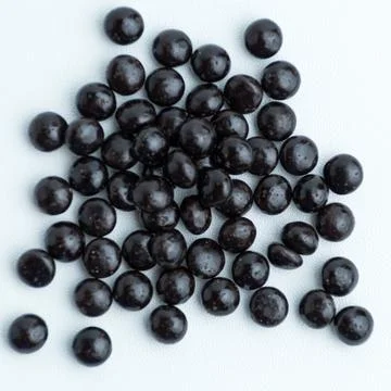Heap of dark chocolate chips drops isolated on a white background Stock Photos