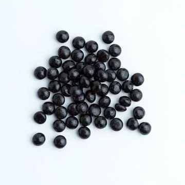 Heap of dark chocolate chips drops isolated on a white background Stock Photos