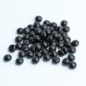 Heap of dark chocolate chips drops isolated on a white background Stock Photos