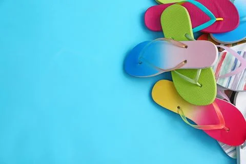 Heap of different flip flops and space for text on blue background, top view. Stock-Fotos