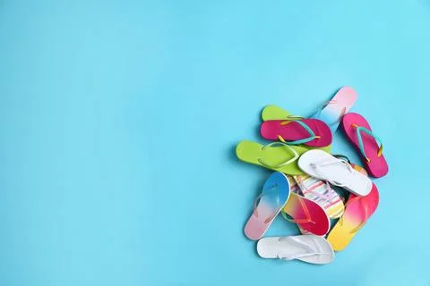 Heap of different flip flops and space for text on blue background, top view. Stock-Fotos