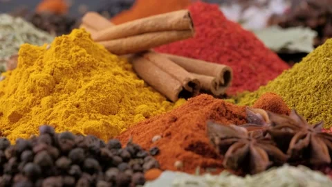 Heap different Indian Spices rotated on wooden table Stock Footage