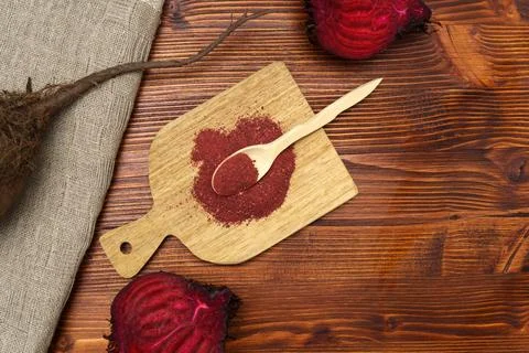 Heap of dried beet root powder, gluten-free beetroot flour. Wooden background Stock Photos