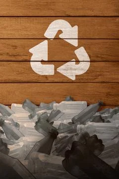 A heap of empty plastic bottles below a white recycling symbol painted on a.. Stock Photos