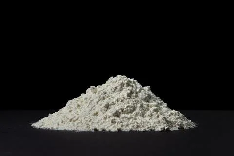 Heap of flour on a black background.  Stock Photos