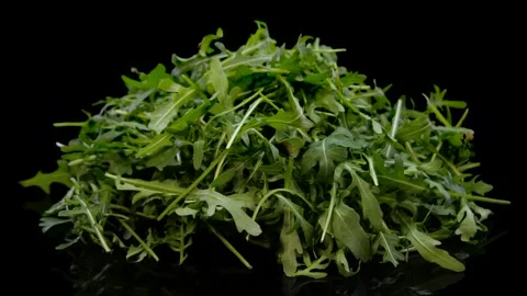 Heap of fresh arugula leaf rotating on a black background. Stock Footage 147295161