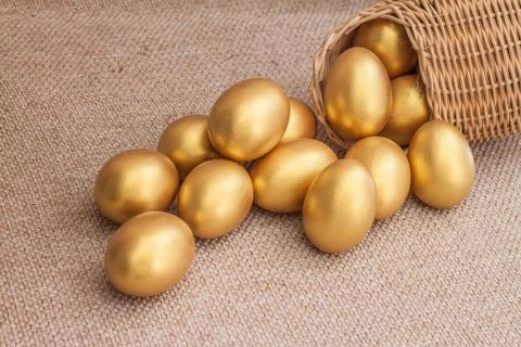 Heap of golden easter egg in wicker basket Stock Photos
