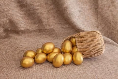 Heap of golden easter egg in wicker basket Stock Photos
