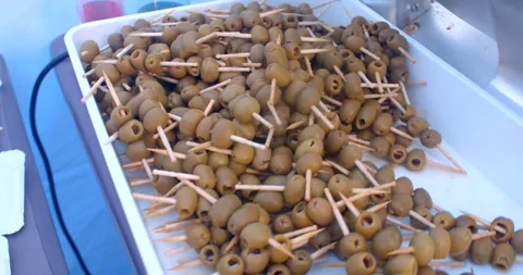 Heap of green olives threaded on toothpicks on white serving tray Stock Footage 347959656