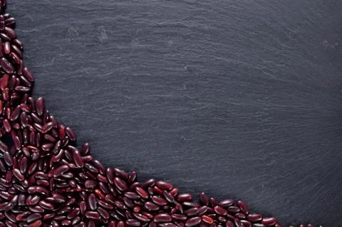 Heap of kidney beans in the left corner on slate slab. Top view frame with Stock Photos