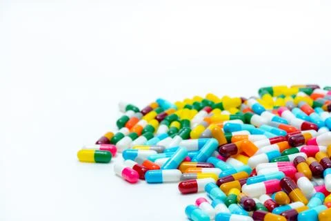 Heap of multi-colored antibiotic capsule pills on white background. Antibioti 库存照片