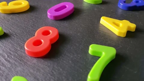 Heap of multicolored numbers on black stone background. Stock Footage 220170497