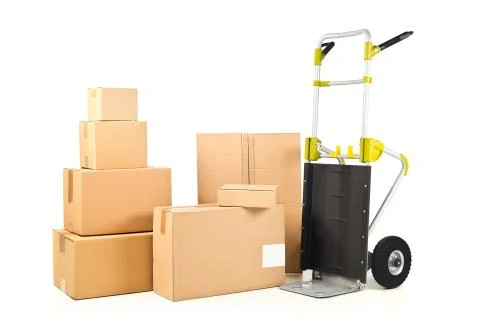 Heap or stack of brown carton transport boxes with barrow over white, deliver Foto stock