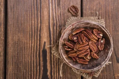 Heap of Pecan Nuts (selective focus) on an old wooden table Stock Photos