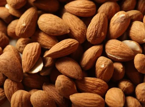 Heap of raw almonds nuts background Stock Photos